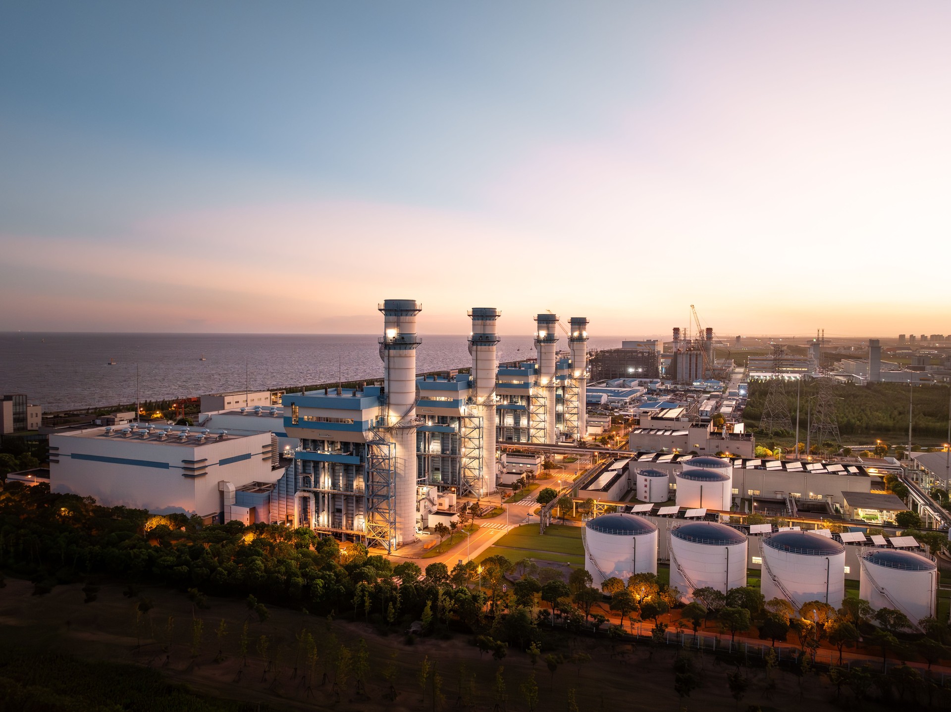 Aerial view of Natural Gas Combined Cycle Power Plant at night. Gas turbine electrical power plant with in Twilight power for factory energy concept.